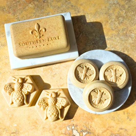 Bar of Southern Luxe soap with bee designs on a textured surface