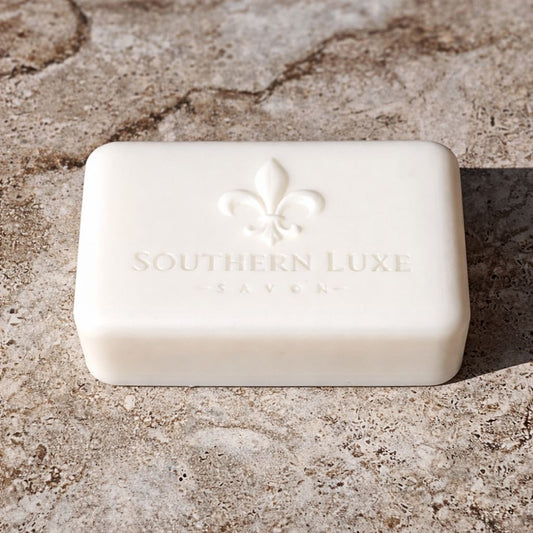 Luxury natural Handmade Dapper from the Barber Bath Bar blends lemon, mint, woods, and musk with rich oils and butters for a smooth, detergent-free cleanse and fresh masculine scent. Large white bath bar with Southern Luxe Savon Soap logo. Coconut Oil, Tussah silk, Kokum Butter. Men's Soap bar.
